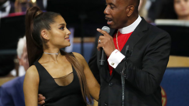 Bishop Charles Ellis, right, holds Ariana Grande after her performance.