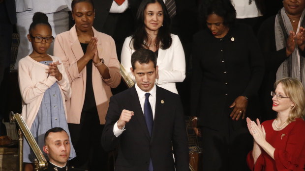Juan Guaido, centre, stands up as Donald Trump introduces him during his third State of the Union address.