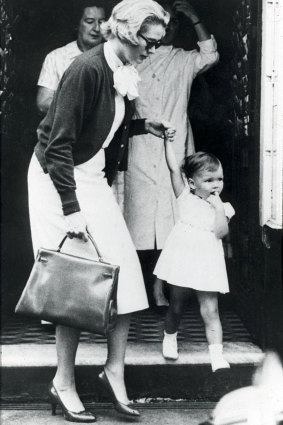 Grace Kelly carries her famous Hermes bag with her daughter Caroline in 1958.