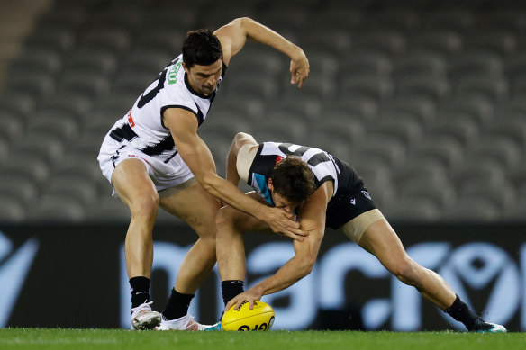 Scott Pendlebury and Travis Boak jostle for the ball.