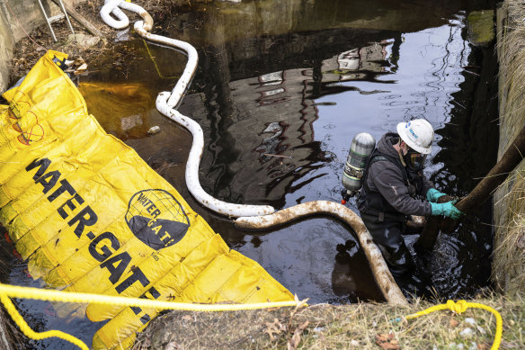 An employee of environmental contractor HEPACO works in a creek along Sumner Street in downtown East Palestine, Ohio on Sunday February 5.