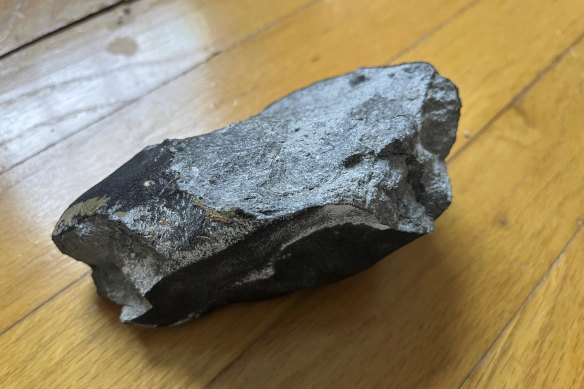 The family who owns the home discovered the black, potato-sized rock - seen here turned over - in a corner still warm. 