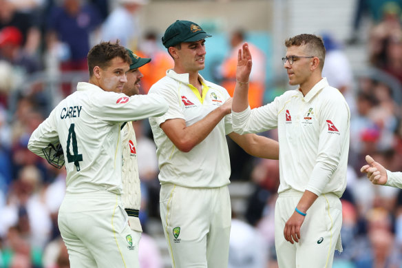 Todd Murphy celebrates with Pat Cummins and teammates after taking the wicket of Moeen Ali.