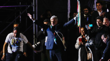 New Mexican President Andres Manuel Lopez Obrador, centre, holds up a ceremonial wooden staff during his inauguration.