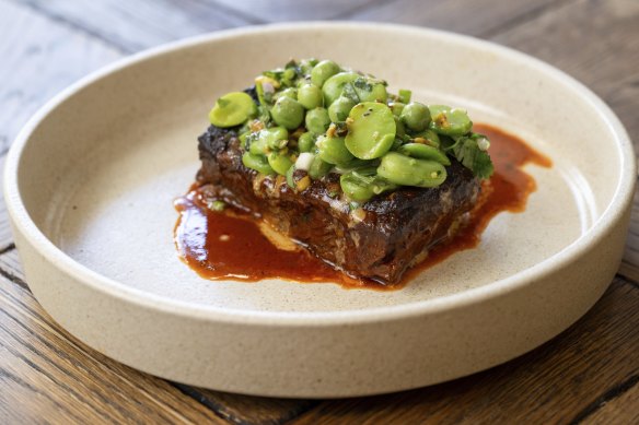 Beef short rib topped with peas, broad beans and pistachios.