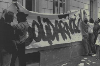 Students hanging Solidarity banner on the wall of Warsaw University preparing a demonstration in support for workers and miners striking nationwide. August 22, 1988.