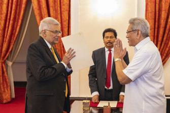 President Gotabaya Rajapaksa, right, greets Ranil Wickremesinghe during the latter’s oath taking ceremony as the new prime minister in Colombo.