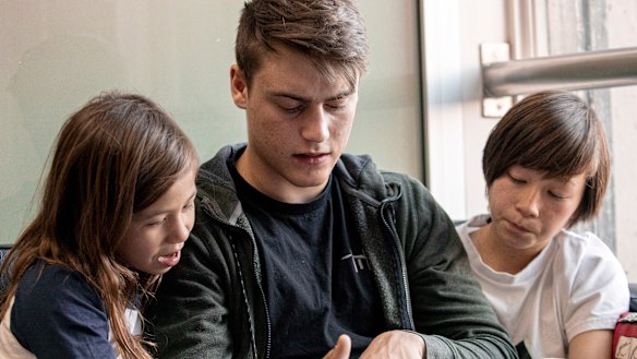 Felix Reiners, an au pair from Germany, reads a book with his charges.