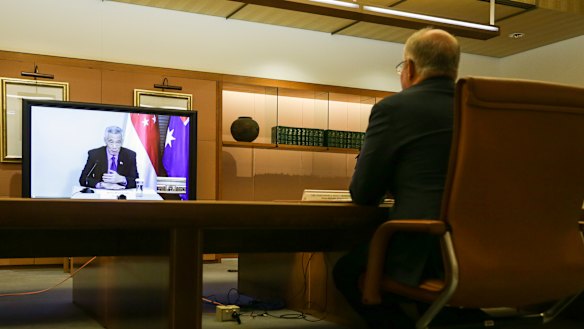 Prime Minister Scott Morrison meets with his Singaporean counterpart Lee Hsien Loong (on the screen) and his delegation during a virtual summit in March. 