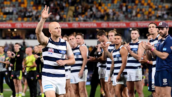 Gary Ablett raises his good arm as he walks through a guard of honour after the grand final