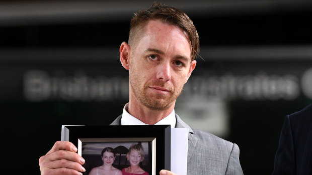 Michael Cooke, brother of Cindy Low, holds a picture of her as he leaves the Magistrates Court in Brisbane.