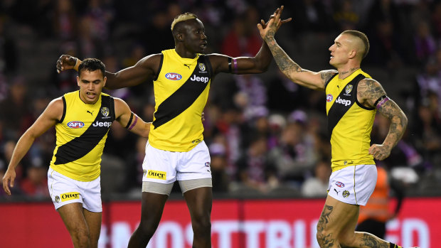 Slotting in: Sydney Stack and Dustin Martin congratulate Mabior Chol (centre) on another major score for Richmond against St Kilda.