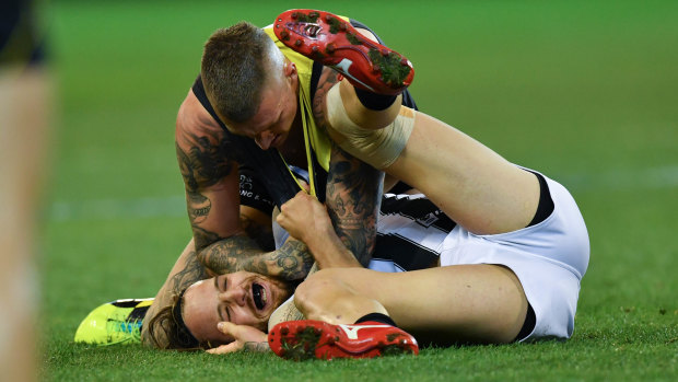 Dustin Martin tangles with Collingwood's James Aish.