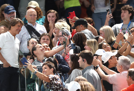 Tom Cruise greets fans during the artistic gymnastics women’s qualification event.