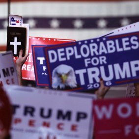 Supporters hold signs and a copy of the Bible during a rally for the then Republican presidential candidate Donald Trump on November 7, 2016, in New Hampshire. 