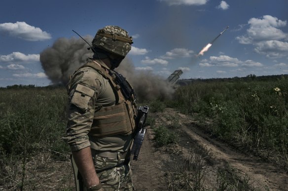 A Ukrainian soldier watches a Grad multiple launch rocket system firing shells with flyers near Bakhmut, Donetsk region.