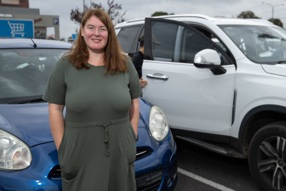Eliza Hiscox and her Nissan Micra in a crowded car park.