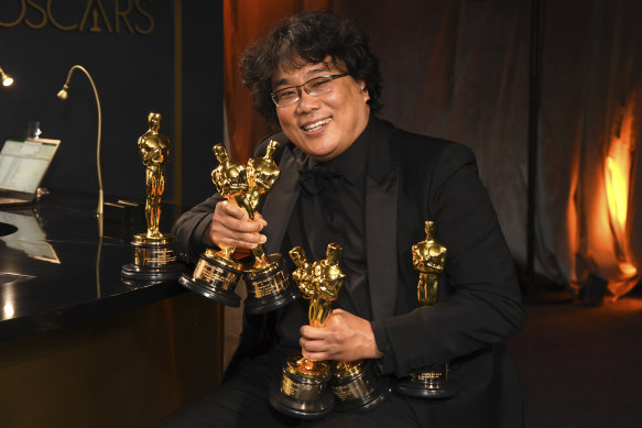 Bong Joon-ho holds the Oscars for best original screenplay, best international feature film, best directing and best picture.