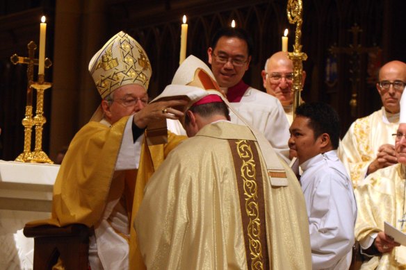 George Pell ordains Peter Comensoli as bishop in 2011.