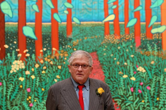 Hockney poses in front of his painting entitled “The Arrival of Spring” in 2011.