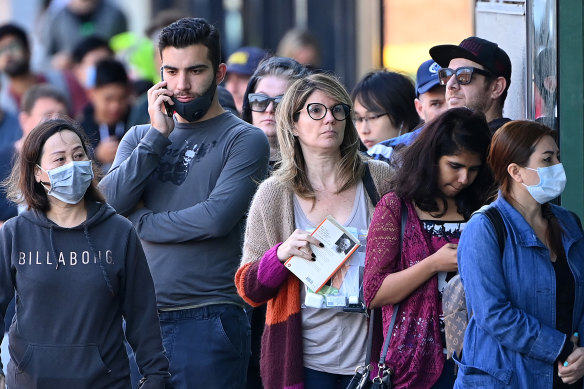 People queue outside Centrelink in Melbourne in March.