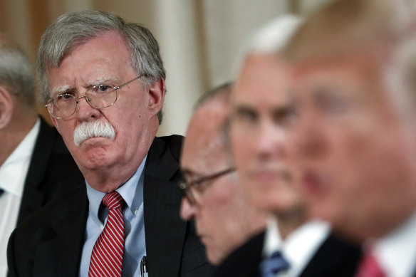 Then national security adviser John Bolton listens to US President Donald Trump in 2018.