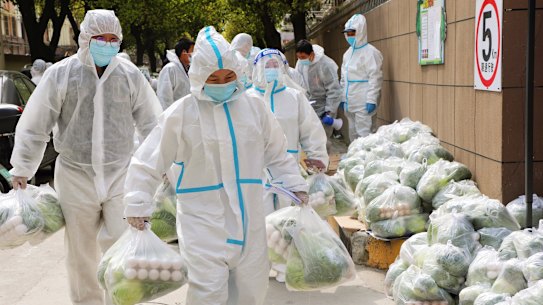 Volunteers carry daily necessities for residents locked down in Shanghai.