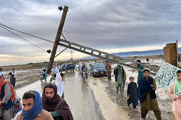 People pass by a damaged electric pole caused by flooding due to heavy rains near Chaman area, Pakistan. Lightning and heavy rains led to 14 deaths in Pakistan, officials said Wednesday, bringing the death toll from four days of extreme weather to at least 63, as the heaviest downpour in decades flooded villages on the country’s southwestern coast. Flash floods have also killed dozens of people in neighbouring Afghanistan.