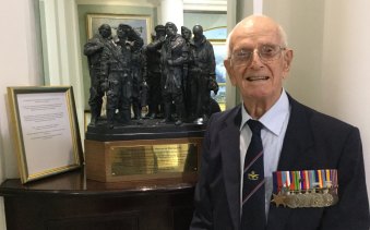 Bob Wade at the RAF Club, London, with a maquette of the Bomber Command sculpture in Green Park.