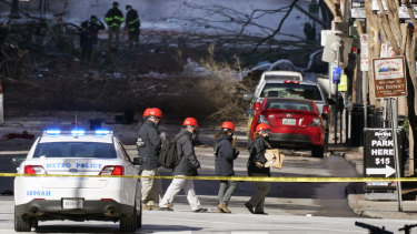 Investigators walk near the scene of an explosion at Nashville, Tennessee. The explosion shook the largely deserted streets of downtown Nashville early on Christmas morning.