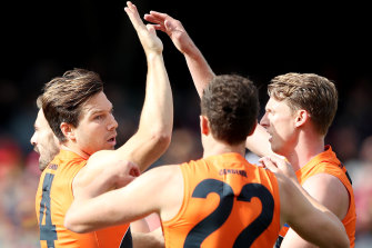 Toby Greene celebrates a goal with Josh Kelly and Lachie Whitfield.