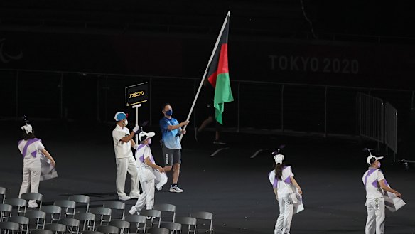 A volunteer holds the flag of Afghanistan. 