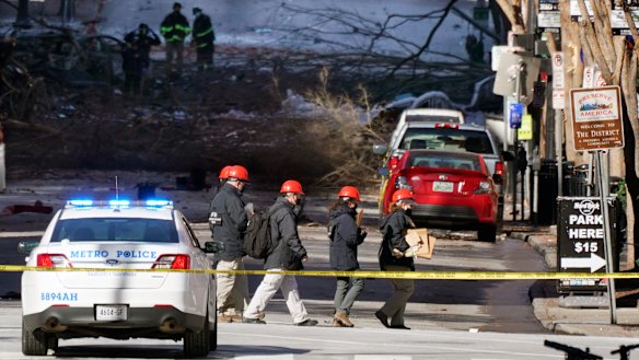 Investigators walk near the scene of an explosion at Nashville, Tennessee. The explosion shook the largely deserted streets of downtown Nashville early on Christmas morning.