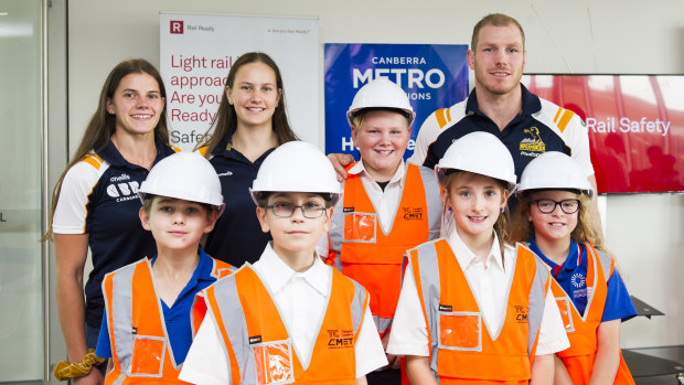 Brumbies players Darcy Read, Claudia Obst and David Pocock with students from Harrison School at the launch of the Tackle Rail Safety Campaign at the Light Rail Depot. 