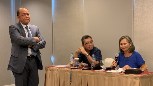 Exiled Cambodia opposition leader Mu Sochua, right, speaks at a press conference in Jakarta, next to  Indonesian activist Darmawan. Cambodian ambassador to Indonesia Hor Nam Bora - who tried to stop the event - looms over the pair.