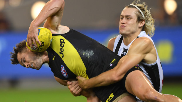 Take down: Darcy Moore tackles Richmond's Maverick Weller during the round two clash at the MCG.