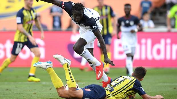 Kenny Athiu of Melbourne Victory is tackled by Jonathan Aspropotamitis of the Central Coast Mariners.