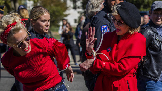 Alpha-gran Jane Fonda (right) high-fives a fellow activist after they were arrested during a rally on Capitol Hill.