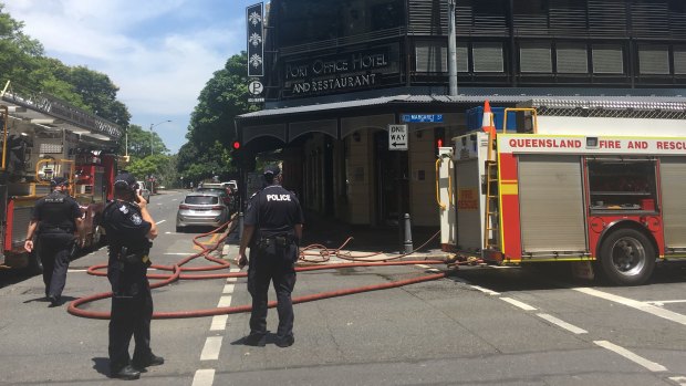 Fire crews close the intersection outside the Port Office Hotel in Brisbane to fight a blaze at the pub.