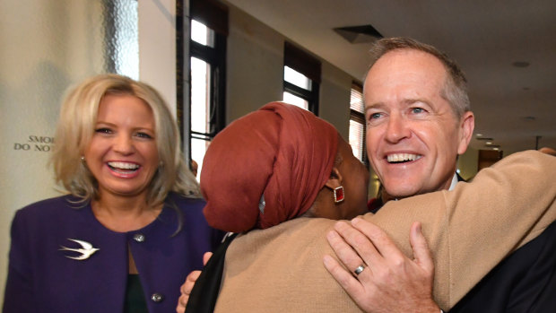 Opposition Leader Bill Shorten hugs Hawa Del as his wife Chloe Shorten  looks on during the launch of Labor's policy to lift the equality of Australian women at the Queen Victoria Women's Centre in Melbourne on Friday. 