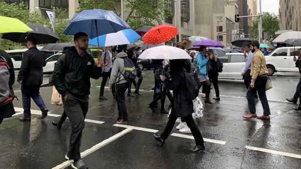 Pedestrians brave the rain in Market Street in Sydney's CBD.