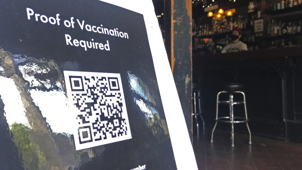 A proof-of-vaccination sign is posted at a bar in San Francisco.