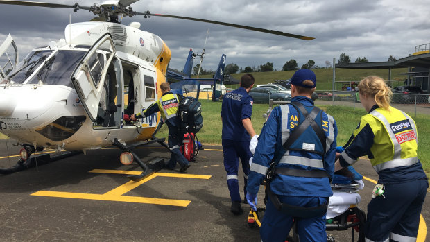 The injured woman is taken to the CareFlight helicopter to be flown to hospital.