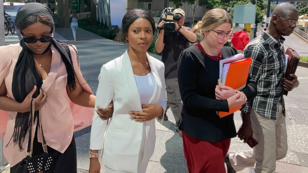 Haja Timbo (second from left)  leaves Brisbane Magistrates Court on Friday after being sentenced to 80 hours community service. 