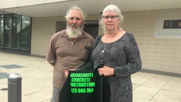 Kay Catanzariti, pictured with her husband Barney and holding the jumper her son Ben was wearing when he died on a construction site on the Kingston foreshore.