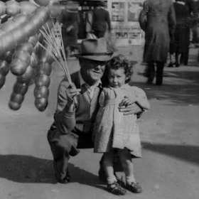 Marjorie Chant as a toddler at the 1950 Royal Melbourne Show with balloon seller Digger McCarthy.