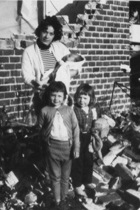 "Mrs V. Norman stands amid the rubble of her earthquake-ruined home at Meckering, W.A., with her three daughters. They were inside when the house collapsed on Monday, but all escaped injury." October 16, 1968