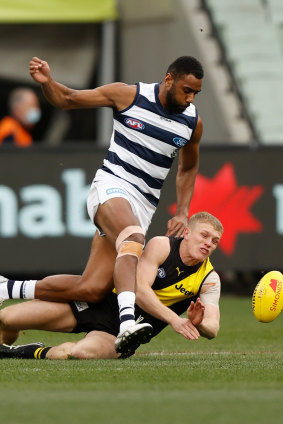 Ryan Garthwaite of the Tigers and Esava Ratugolea of the Cats compete for the ball at the MCG.
