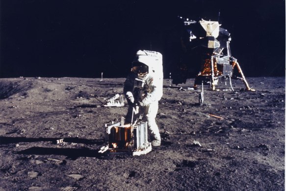 Buzz Aldrin deploys an experiment on the surface of the moon.