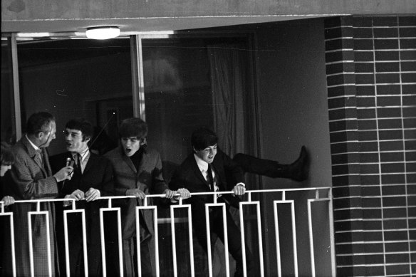John Lennon, a reporter, Jimmy Nicol, George Harrison and Paul McCartney on the balcony of the Beatles' hotel room.